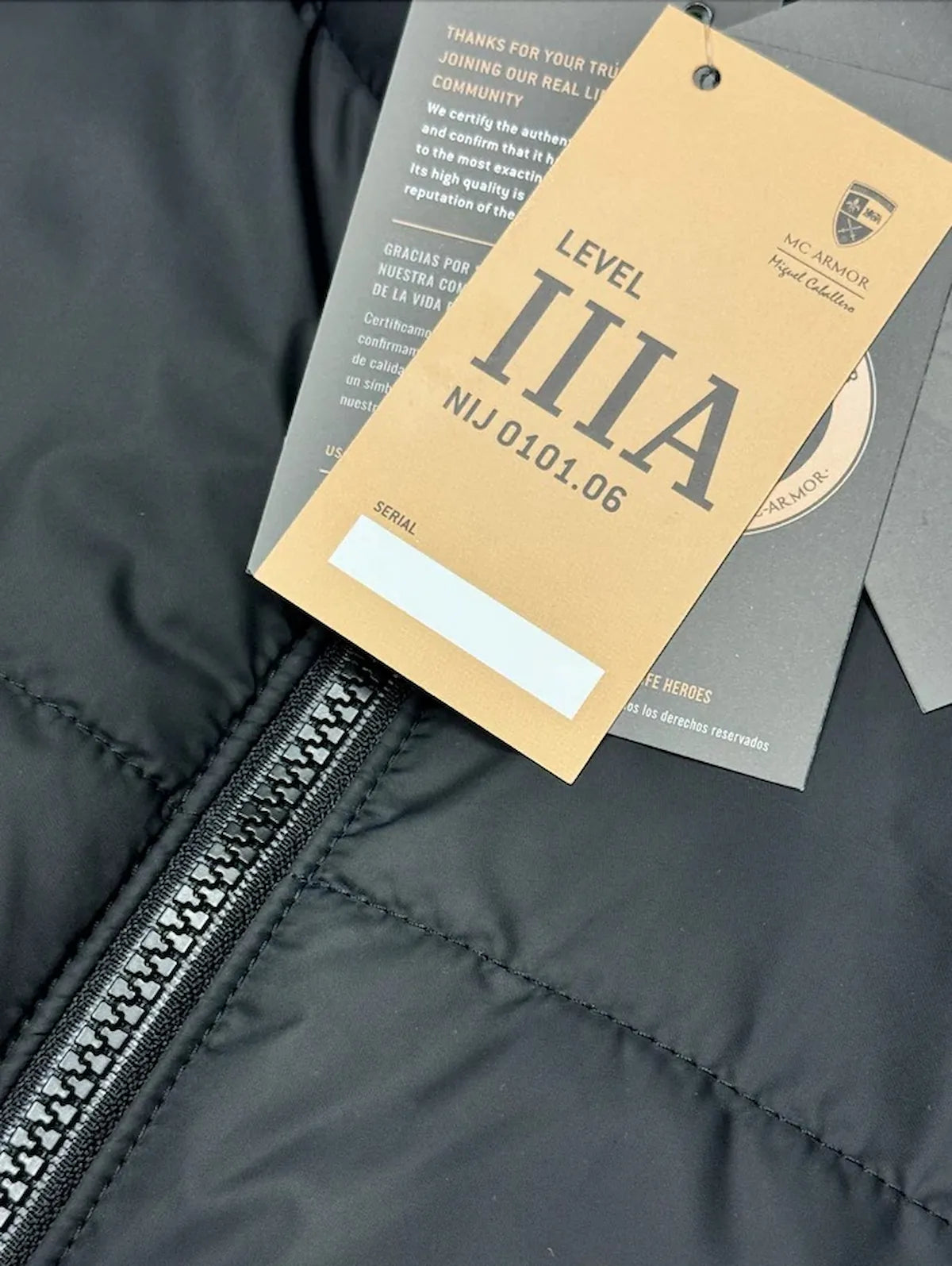 Etiqueta oficial de certificacion Nivel IIIA bajo la norma NIJ 0101.06 colocada sobre una prenda blindada negra, garantizando proteccion contra impactos balisticos de armas de fuego.
